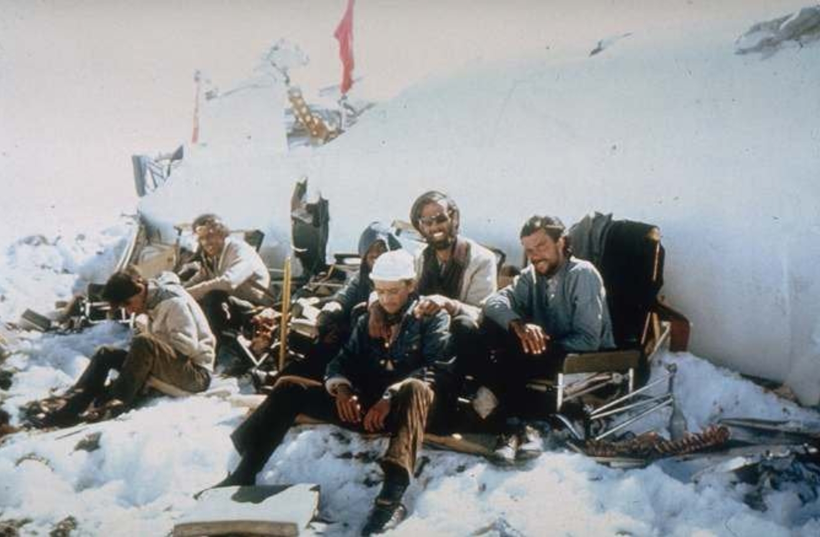 photo of the survivors of the andes plane crash in 1972. notice the spine laying beside them on the right.